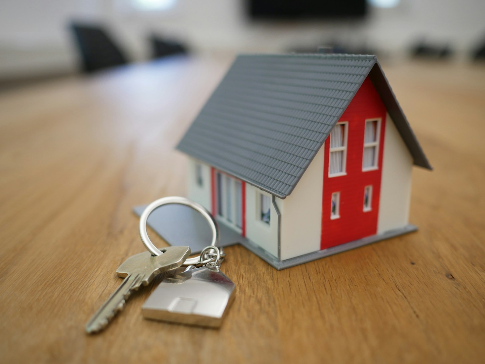 white and red wooden house miniature on brown table, home insurance