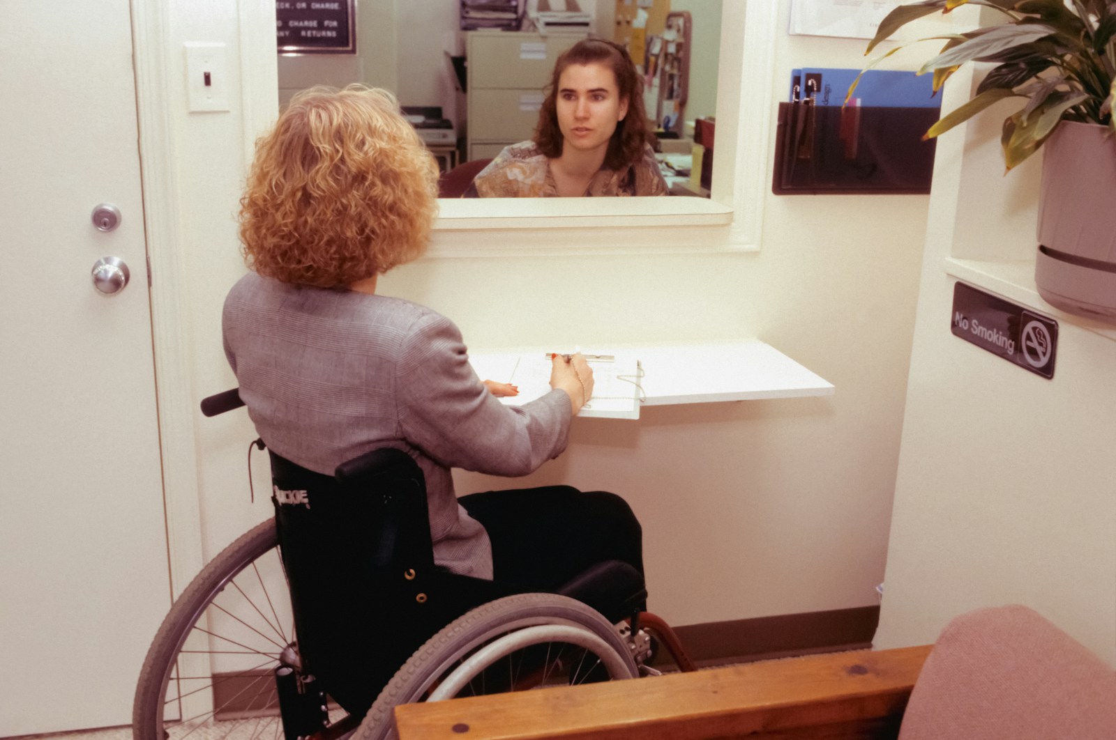 a woman sitting in a wheel chair in front of a mirror, disability